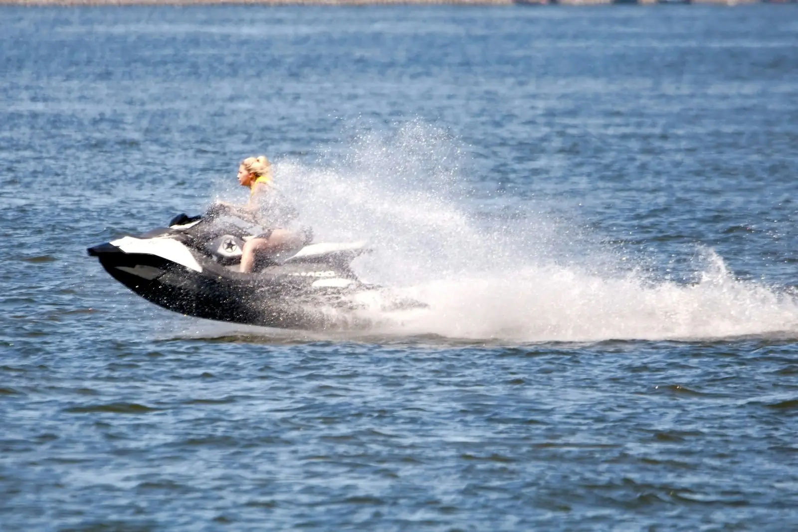 Rider leaning into a jet ski turn on open water