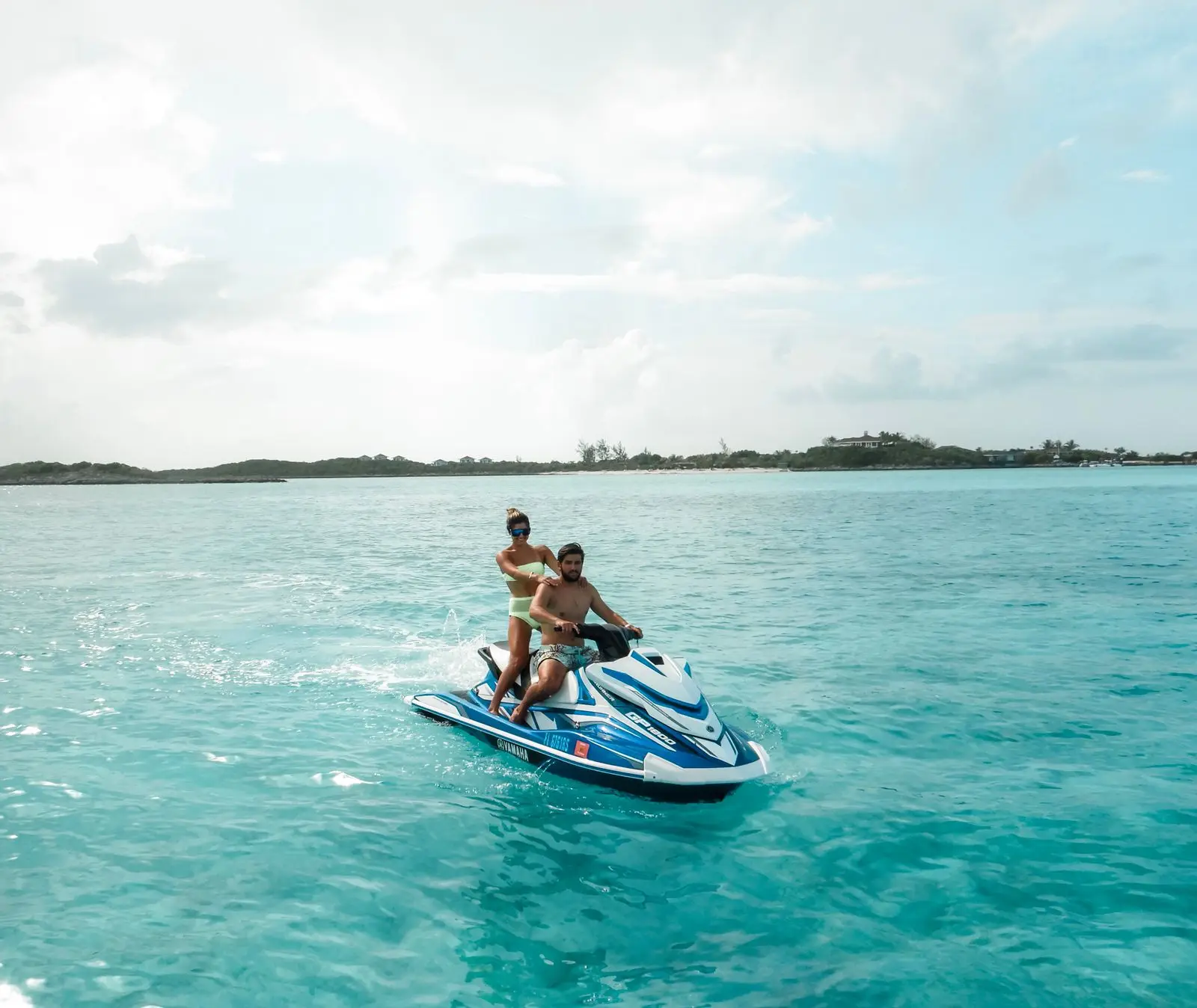Two friends riding a jet ski together, smiling